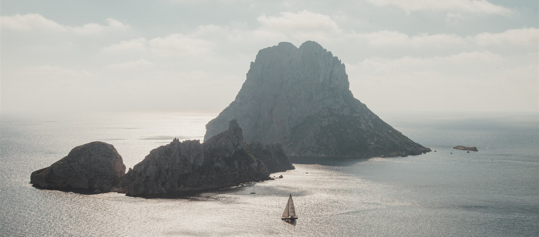 A boat below mountain cliffs