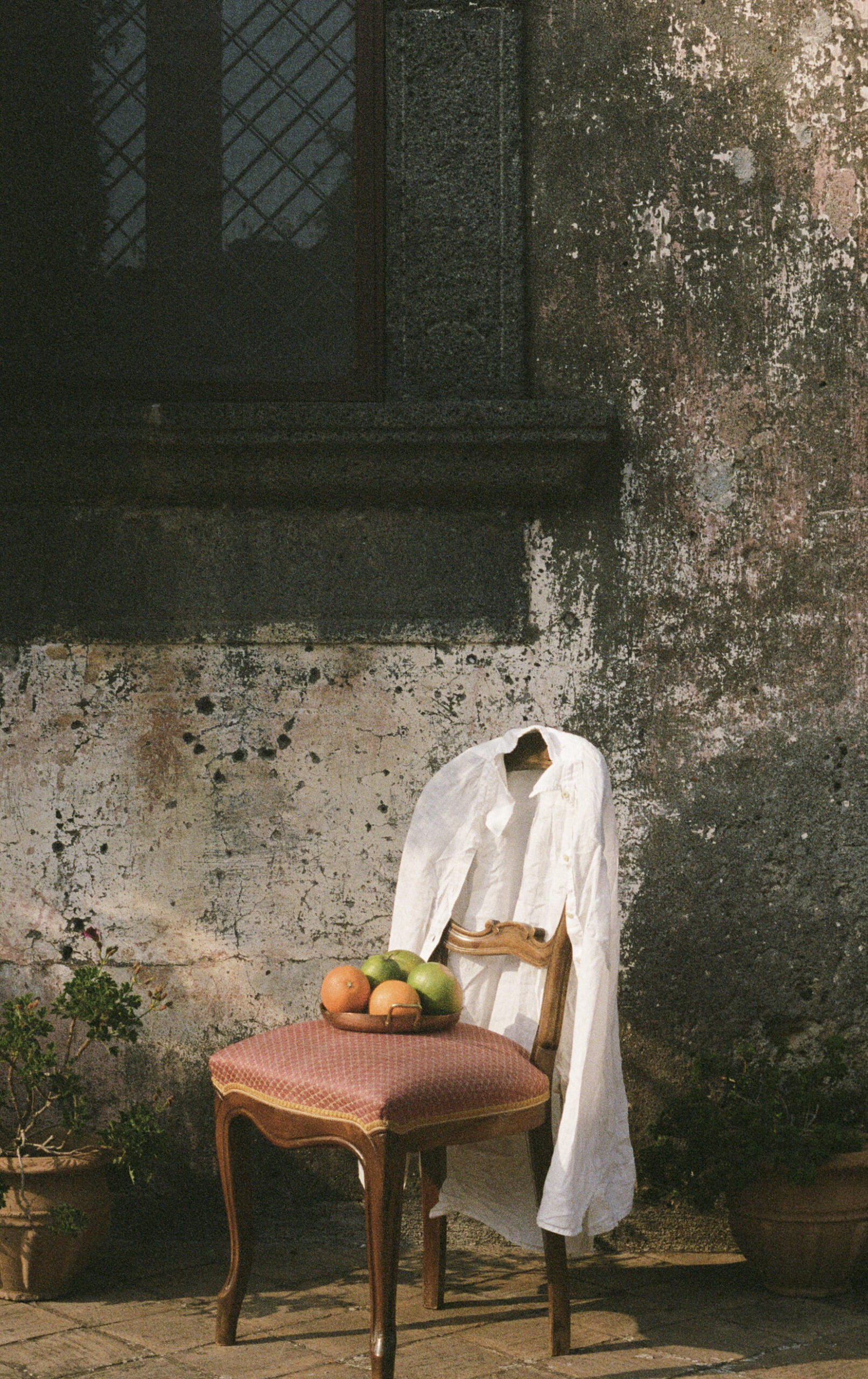 A chair beside a weathered wall
