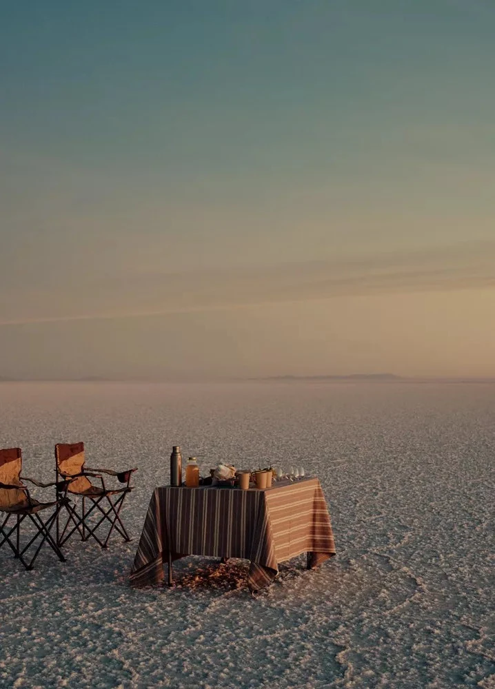 Dinner table for two beside the sea at sunset